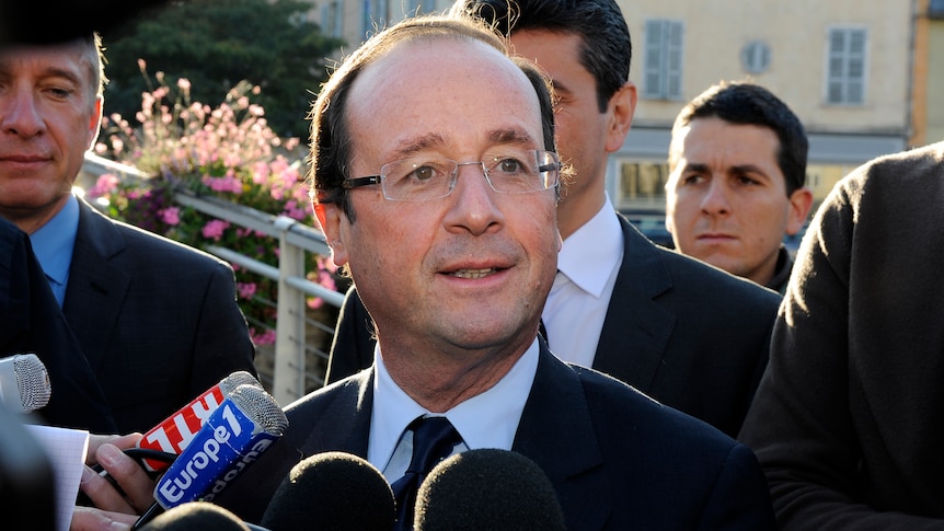 Francois Hollande speaks to journalists in western France as he leaves a polling station.
