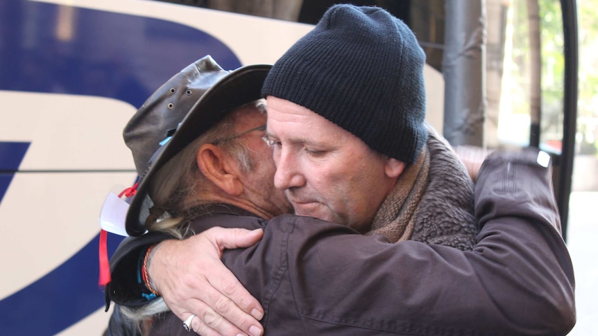 Child abuse survivors hug before leaving Rome