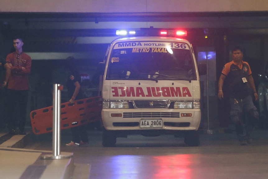 Rescue workers carry a stretcher inside a hotel at the Resorts World Manila complex.