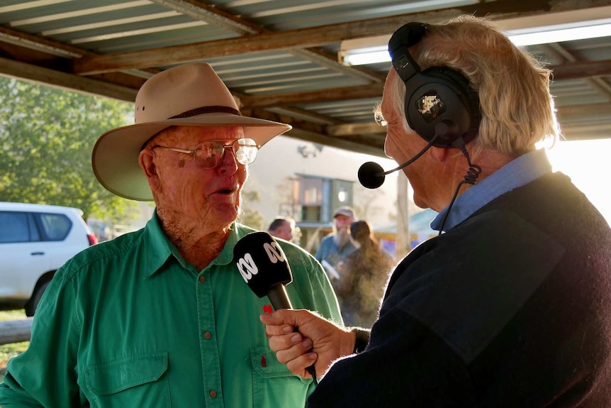 Pritchard interviewing a farmer wearing an Akubra hat.