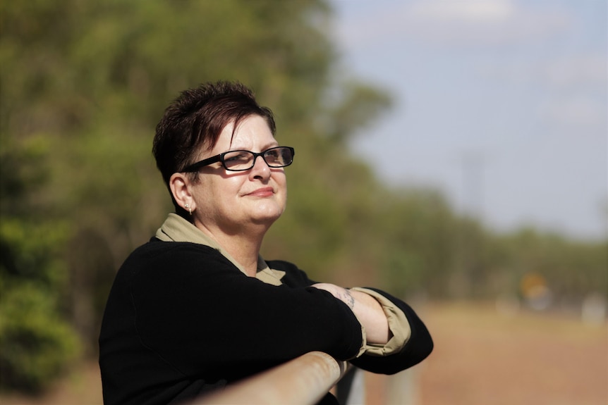 Tracey Hyde stands at a fence looking into the distance.