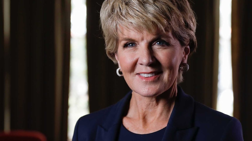 Julie Bishop looks into the camera while standing in a room with the curtains drawn.