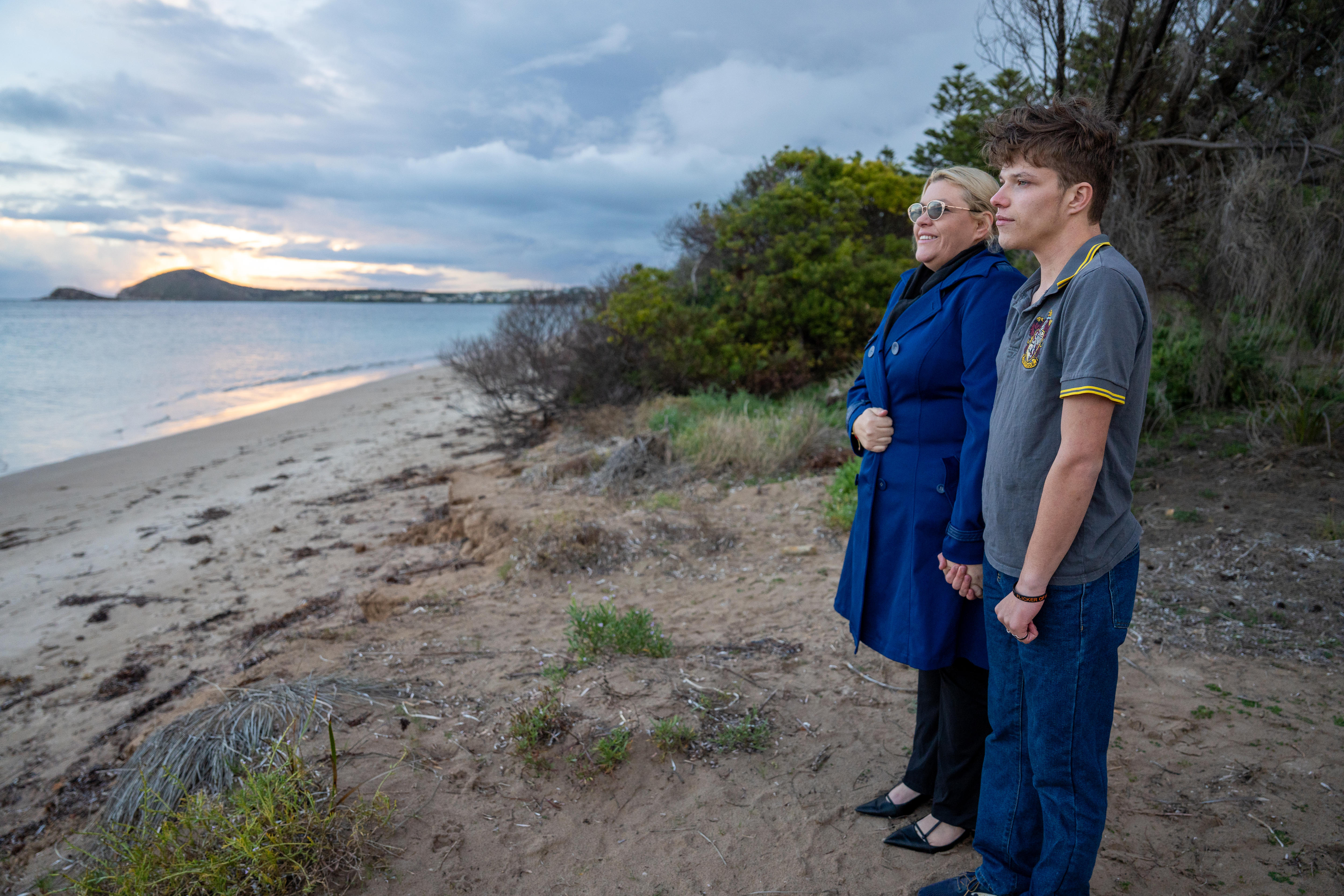 A mother and son stare out to the ocean