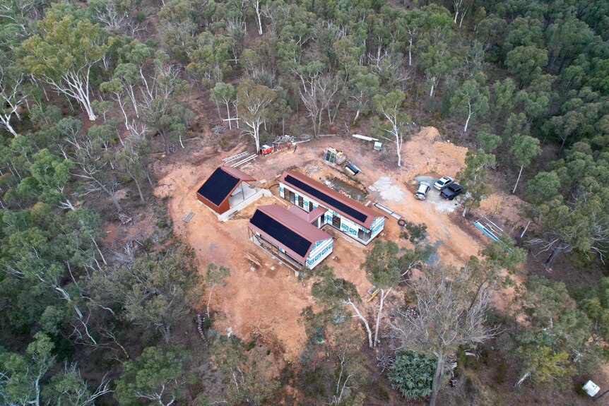 Vue aérienne de la maison entourée de brousse. 