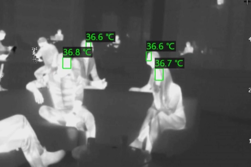 Black and white thermal imaging of people showing their temperatures