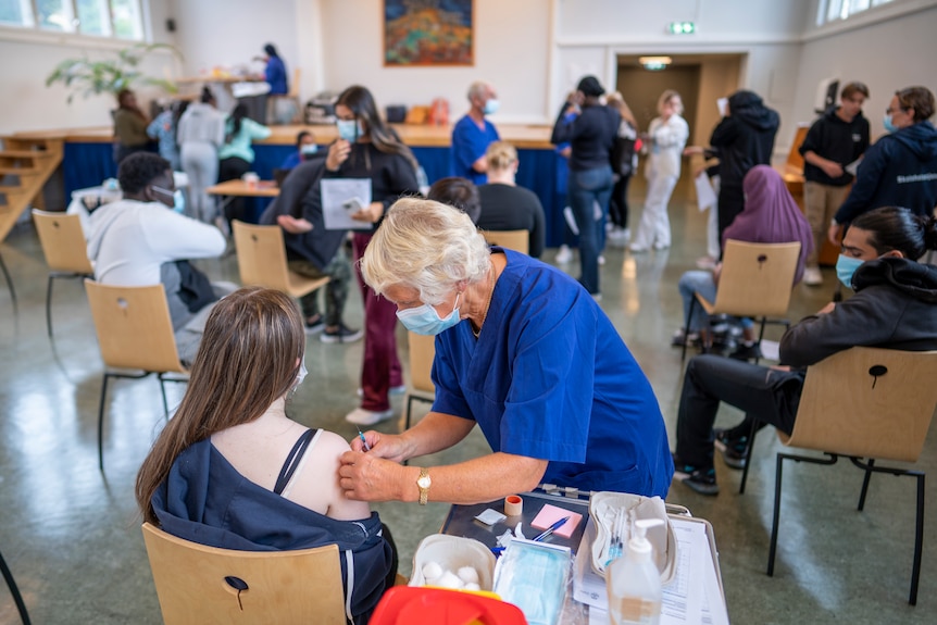 People sit in a COVID-19 mass vaccination centre.