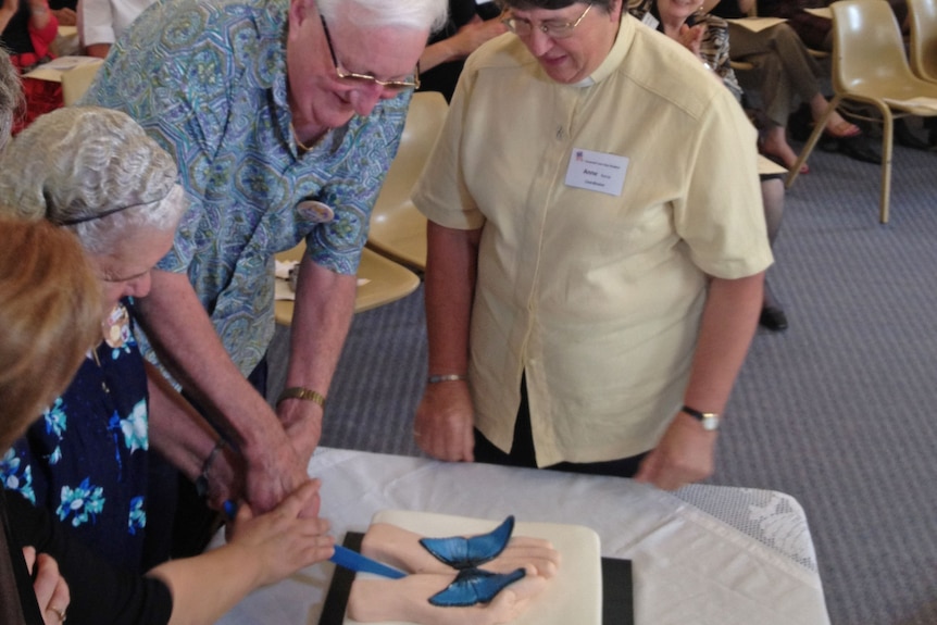 Carers help cut a cake at the opening of the Covenant Care Day Hospice.