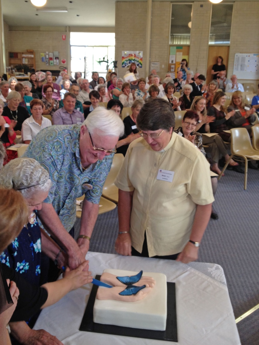 Carers help cut a cake at the opening of the Covenant Care Day Hospice.