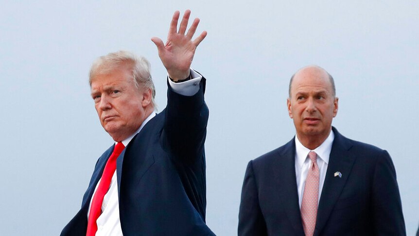 Donald Trump and Gordon Sondland are pictured against an overcast sky as the president waves to cameras with one hand.