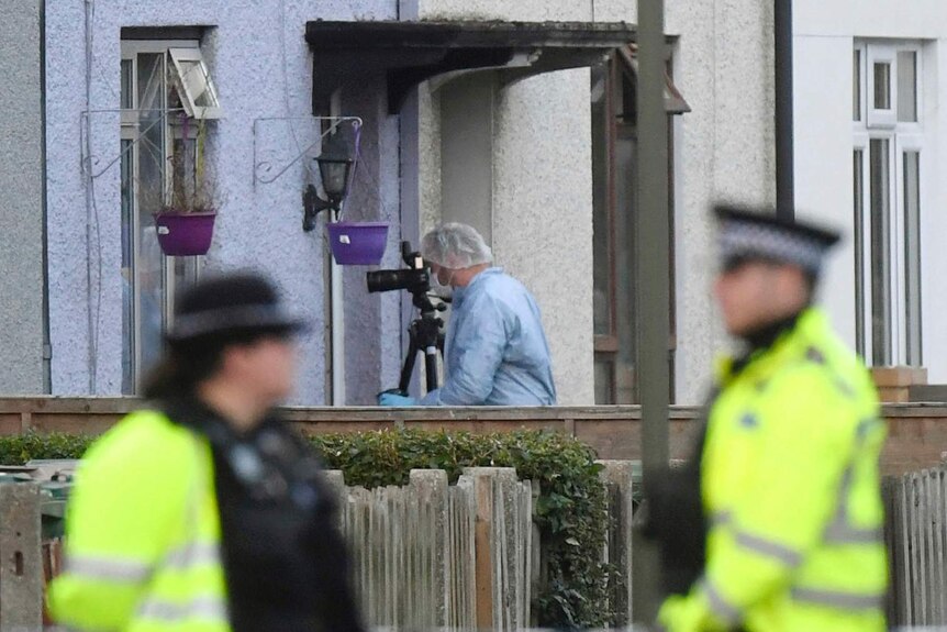 Police and forensic officers work at a property in Sunbury-on-Thames,