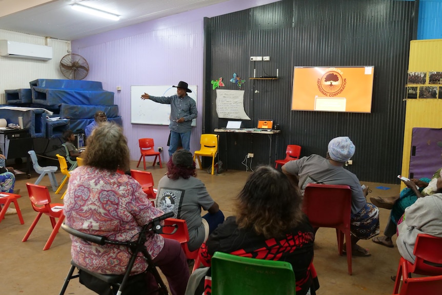 An Aboriginal man giving a presentation to people.