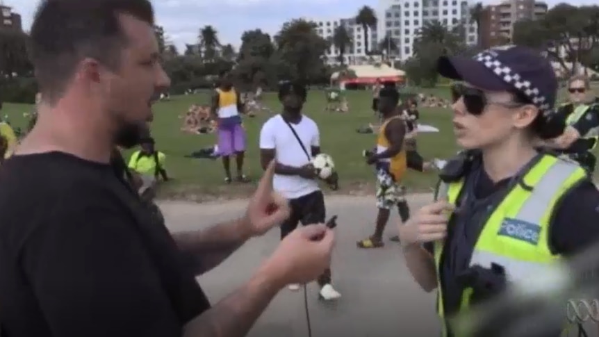 Neil Erikson speaks to a female police officer in a high-vis jacket.