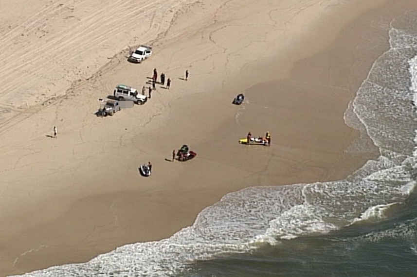 Authorities and other people on jet skis gathered on a South Stradbroke Island beach.