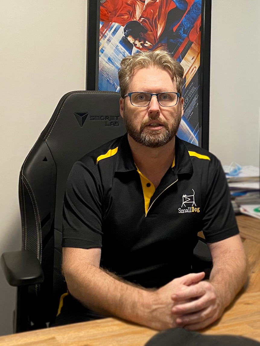 Man sitting at desk looking at camera.