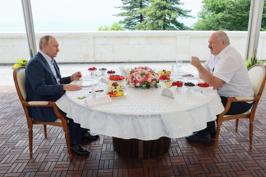 Putin and Lukashenko chat over a breakfast table decorated with flowers 