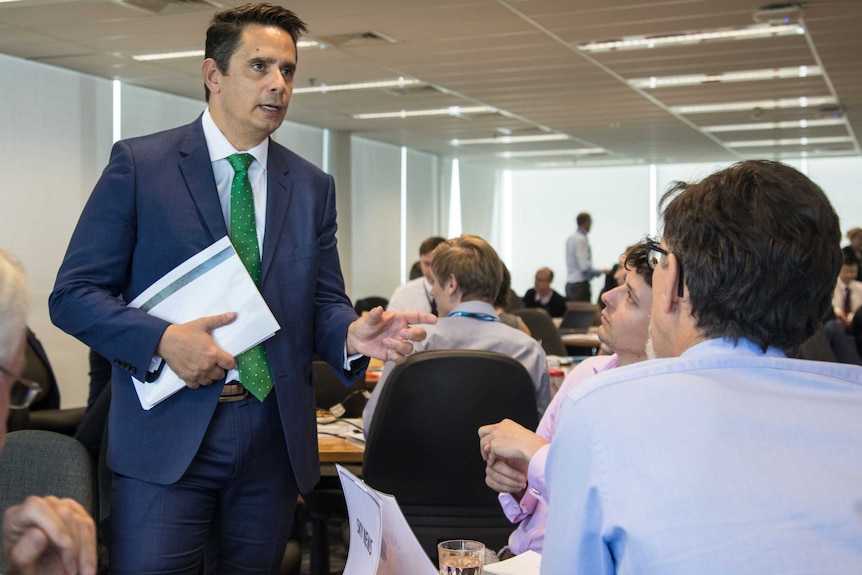 WA Treasurer Ben Wyatt speaks to journalists while holding budget papers