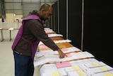 Australian Electoral Commission representative examines Senate ballot papers