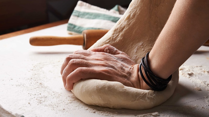Close-up of a person kneading dough