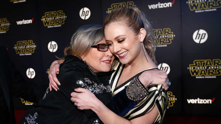 Actresses Carrie Fisher (L) and Billie Lourd embrace and smile at the Star Wars: The Force Awakens premiere in Hollywood.
