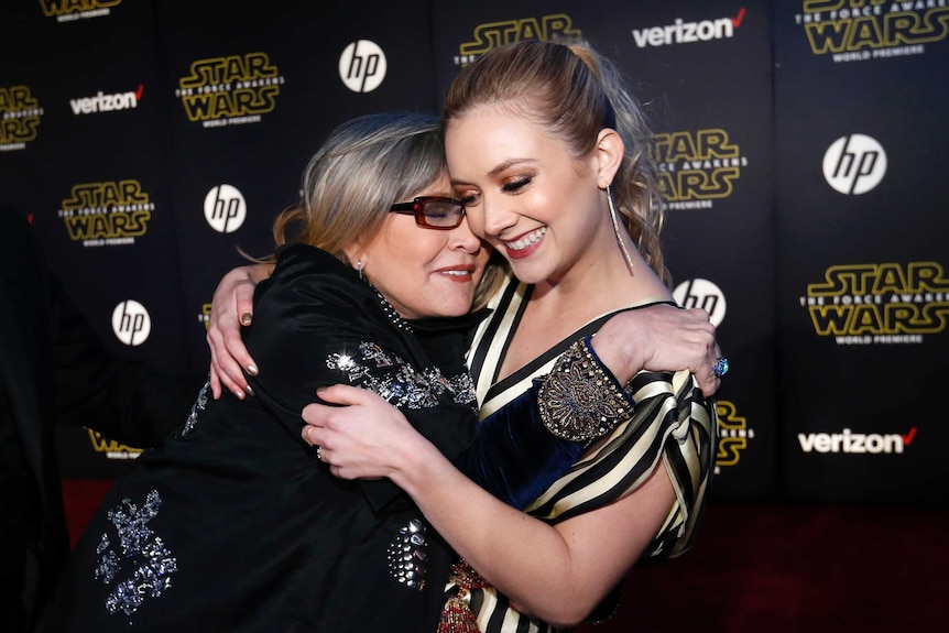 Actresses Carrie Fisher (L) and Billie Lourd embrace and smile at the Star Wars: The Force Awakens premiere in Hollywood.