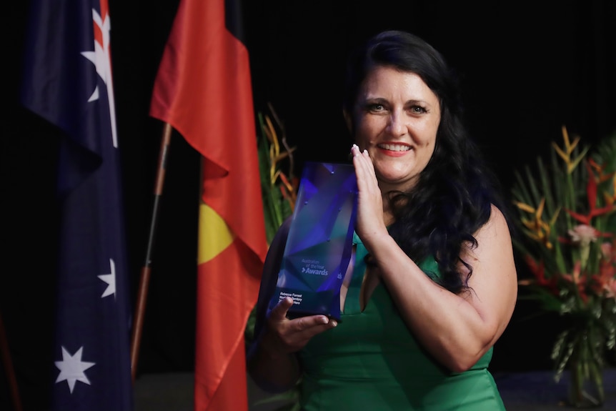 Rebecca Forrest stands holding her NT Local Hero award.