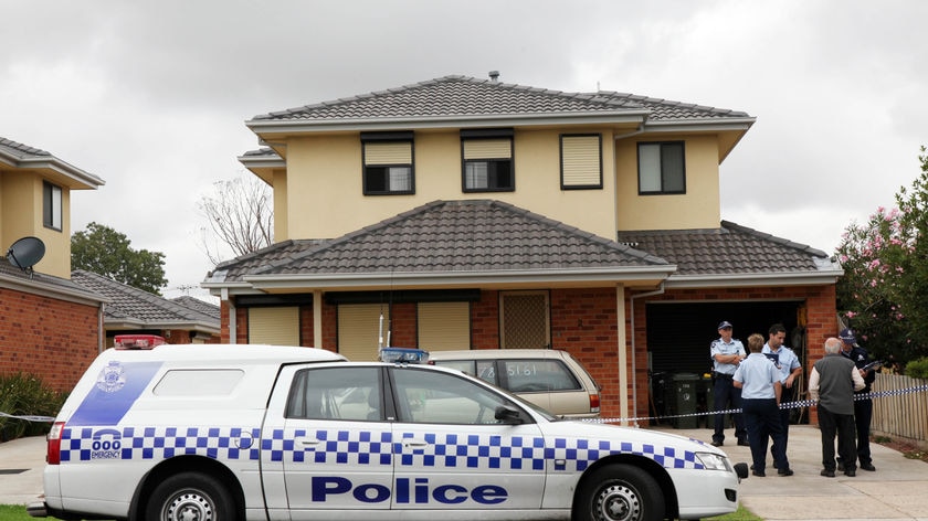 Police investigate at the home where Herman Rockerfeller's alleged murderers were arrested.