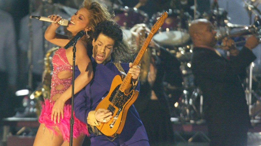 Prince and Beyonce perform together on stage with the band behind them.