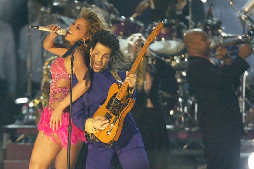 Prince and Beyonce perform together on stage with the band behind them.