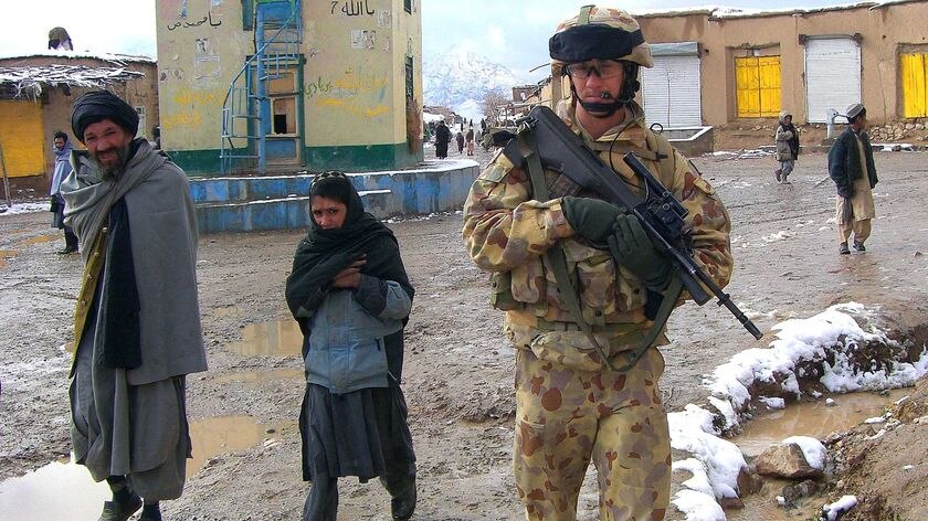 Captain Rob Haertsch walks beside Afghan locals in the Chora Valley in Afghanistan