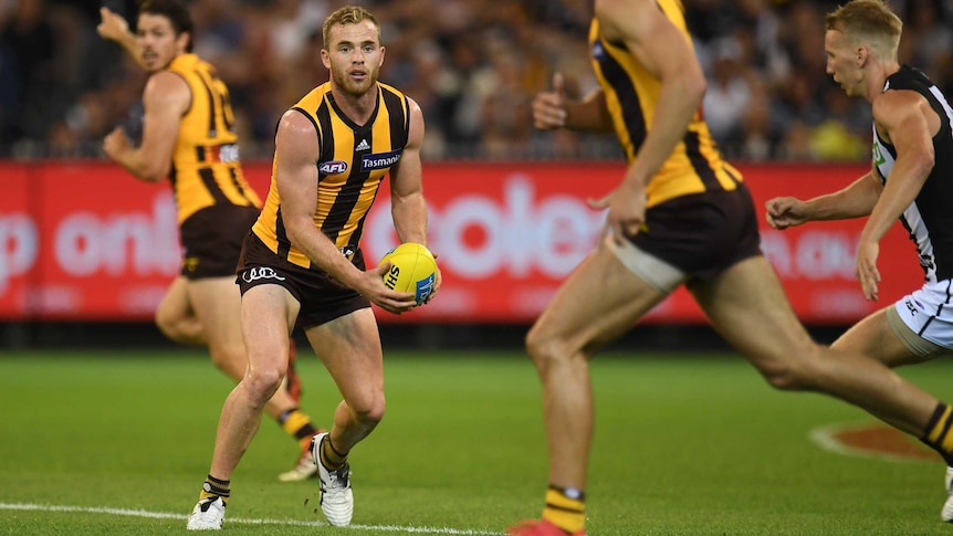 Hawthorn's Tom Mitchell (2nd L) handballs against Collingwood at the MCG on March 24, 2018.