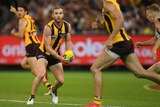 Hawthorn's Tom Mitchell (2nd L) handballs against Collingwood at the MCG on March 24, 2018.