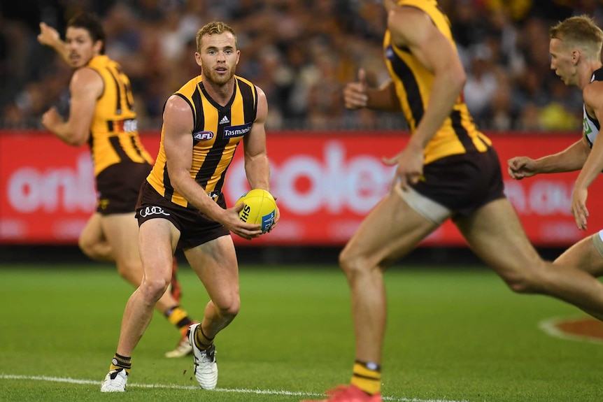Hawthorn's Tom Mitchell (2nd L) handballs against Collingwood at the MCG on March 24, 2018.