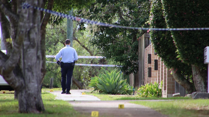 Queensland police detective at scene of Underwood stabbing walking through taped-off area