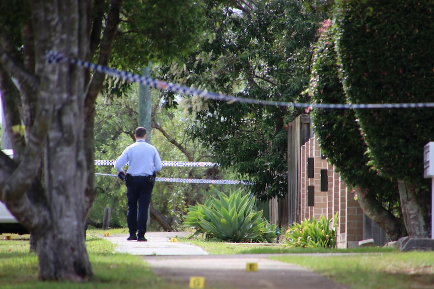 Queensland police detective at scene of Underwood stabbing walking through taped-off area