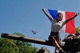 A woman waves a French flag during celebrations of the liberation from Nazi occupation 75 years ago.
