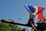 A woman waves a French flag during celebrations of the liberation from Nazi occupation 75 years ago.