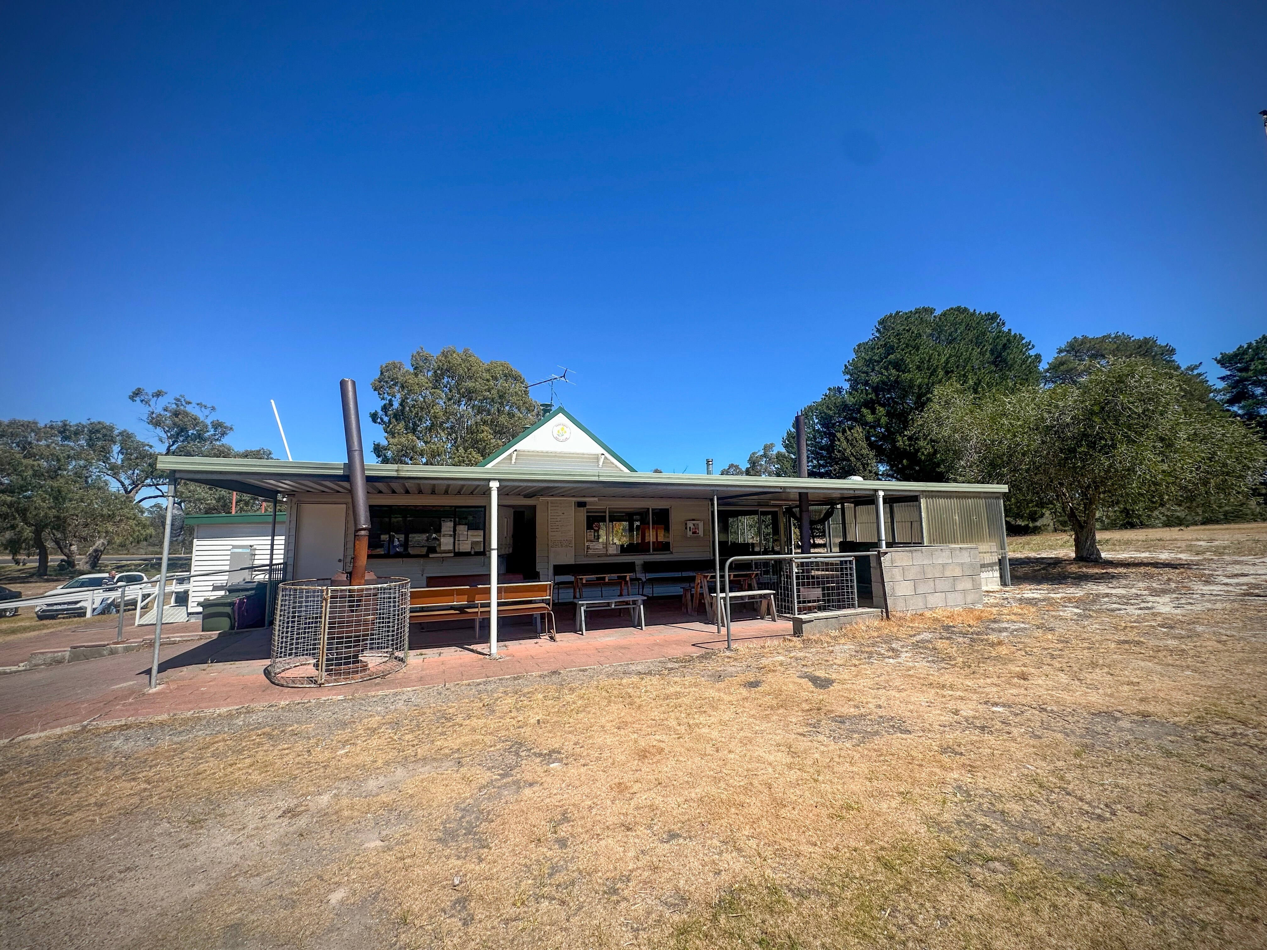 Former outback school building with metal roof erected on semi-arid looking ground.