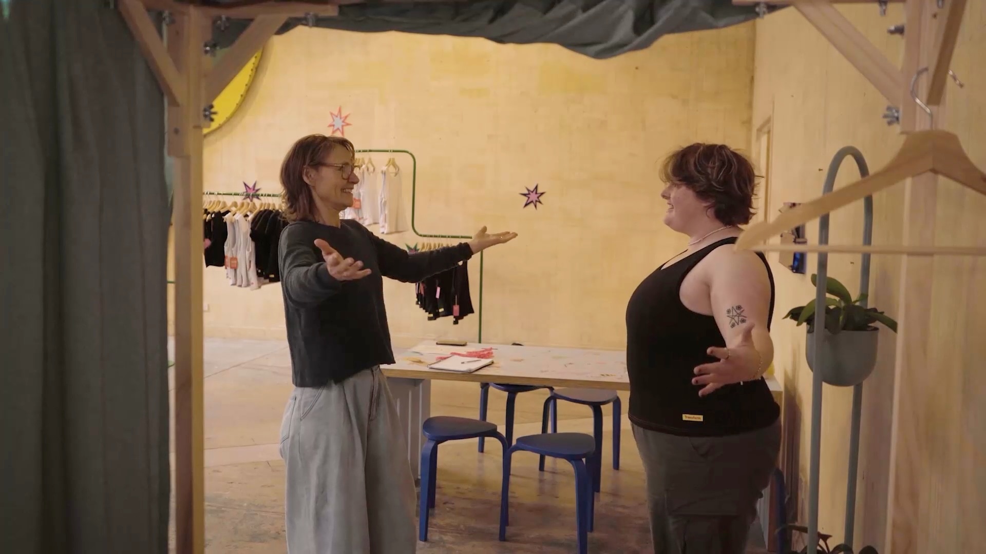 A sales assistant stands in front of a customer who is trying on a binder,