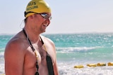 Blind swimmer Jeremy McClure in side profile on the beach in swimming gear.