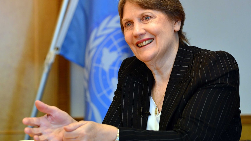 Former NZ prime minister Helen Clark speaks at a desk with a UN flag in the background.