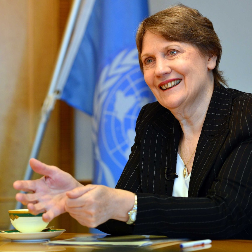 Former NZ prime minister Helen Clark speaks at a desk with a UN flag in the background.