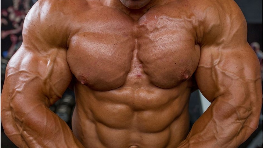 a ripped bodybuilder flexes his chest