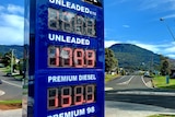 A petrol price board shows the unleaded price of 179.1c per litre, with an escarpment in the background.