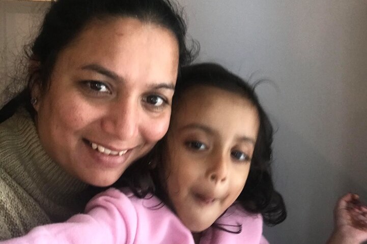 Greeshma Patel smiles at the camera while holding her daughter, Prisha