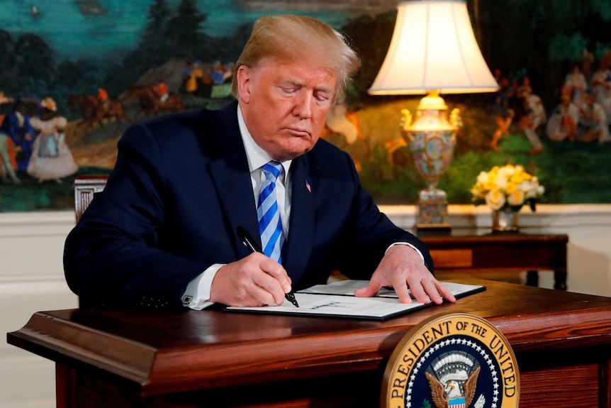 Donald Trump signs a paper
