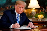 Donald Trump signs a paper