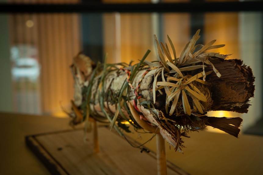 Close up view of traditional bark and botanicals fire stick on  a display stand.