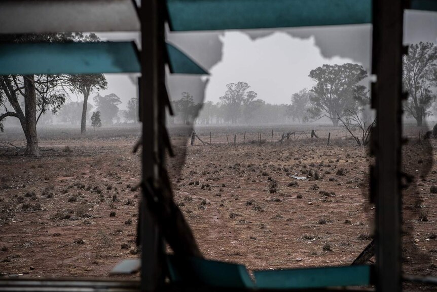 Drought-affected land can be seen through the windows of an abandoned home in Parkes, NSW.