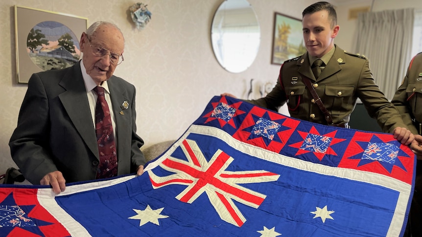 Two men with an Australian flag blanket