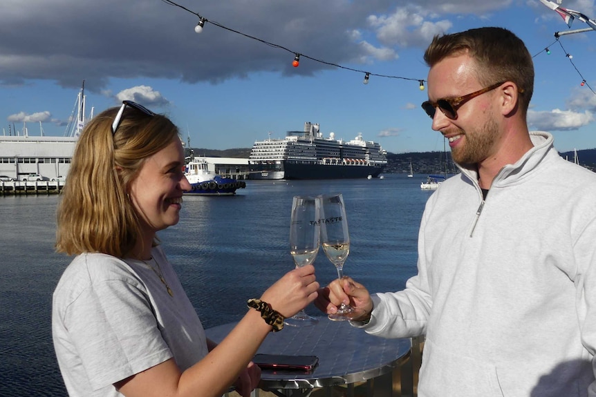 A man and a woman cheers their champagne glasses